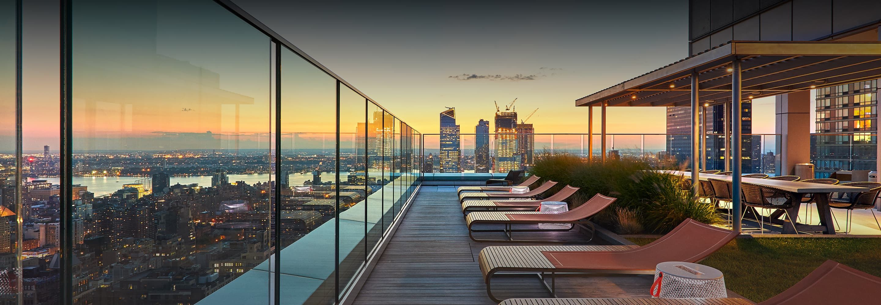 A panoramic view of the New York City skyline from EOS' rooftop, showcasing iconic skyscrapers against a clear blue sky from the NoMad area.