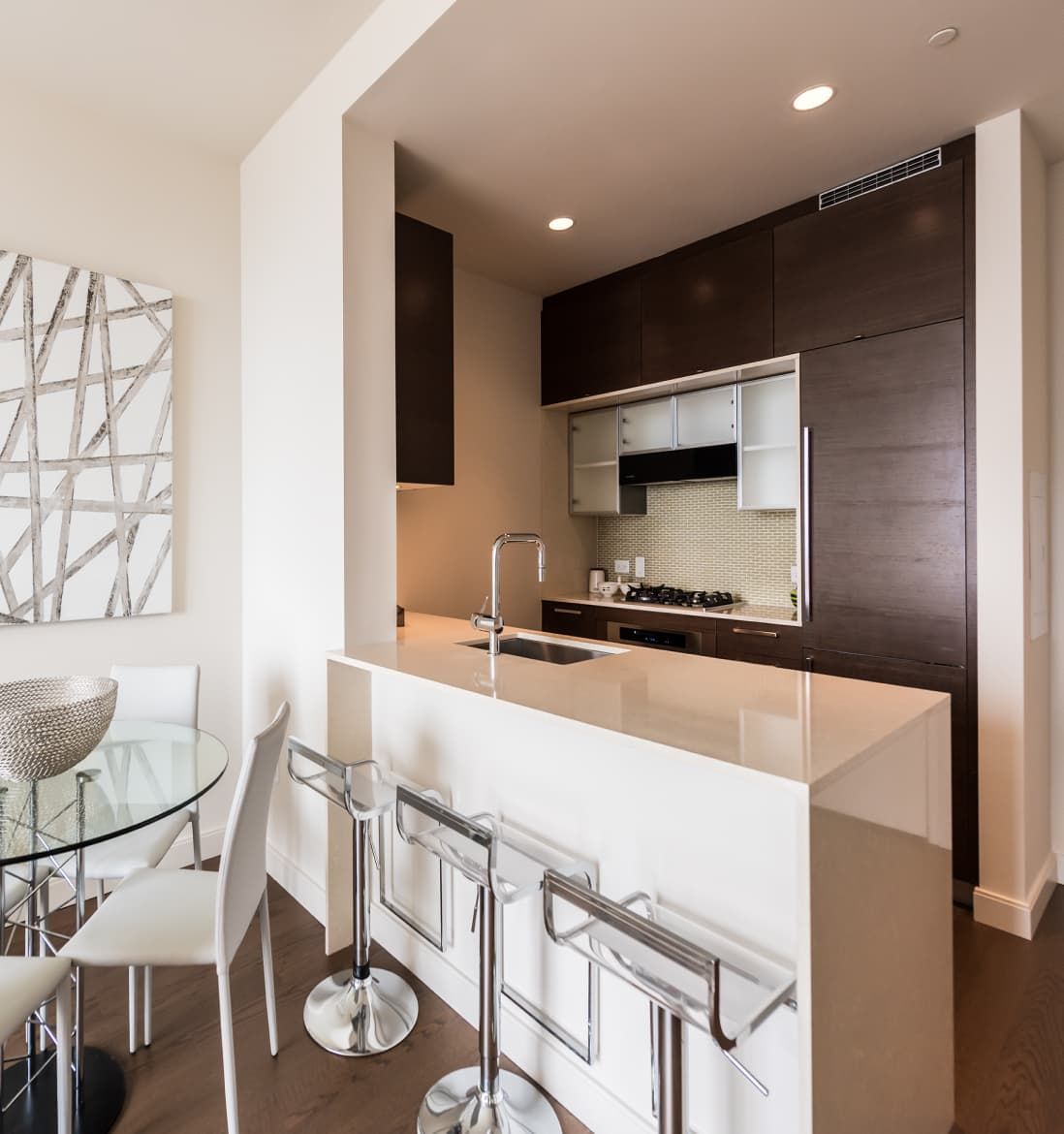 A contemporary kitchen with a bar counter and a refrigerator, highlighting an inviting space for cooking and socializing.