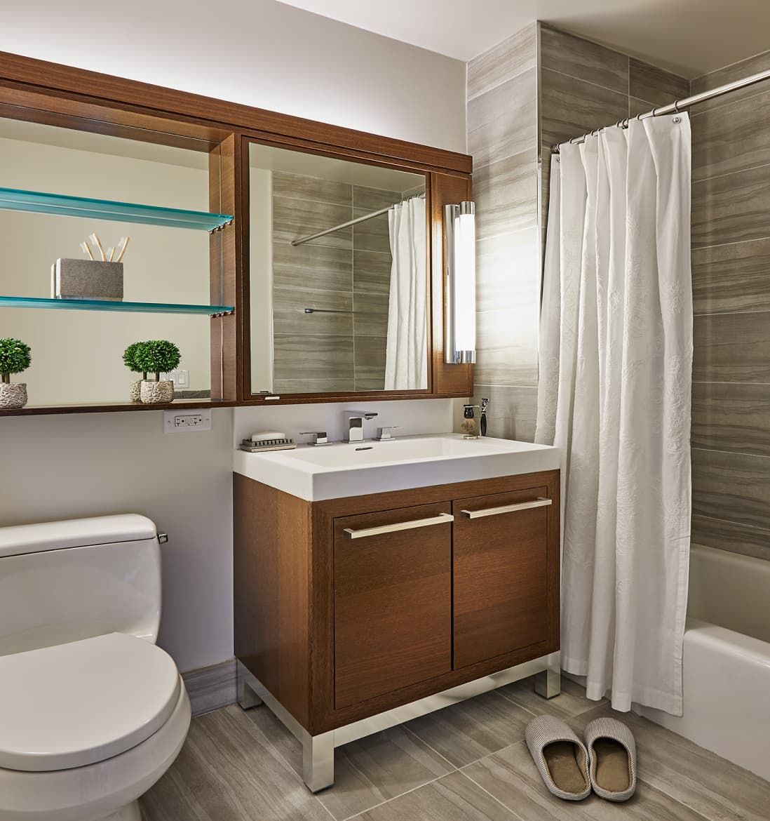 A modern bathroom showcasing a toilet, sink, and shower, emphasizing a sleek and practical layout.